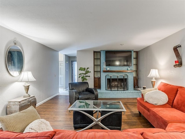 living room with dark hardwood / wood-style flooring and a brick fireplace