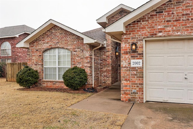 doorway to property with a garage and a lawn