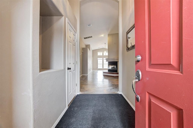 entryway with vaulted ceiling and carpet flooring