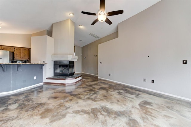 unfurnished living room featuring ceiling fan, a multi sided fireplace, high vaulted ceiling, and concrete floors