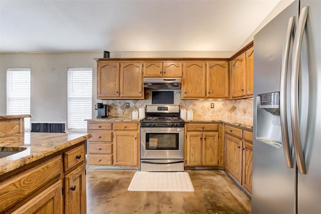 kitchen featuring stainless steel appliances, light stone countertops, and decorative backsplash