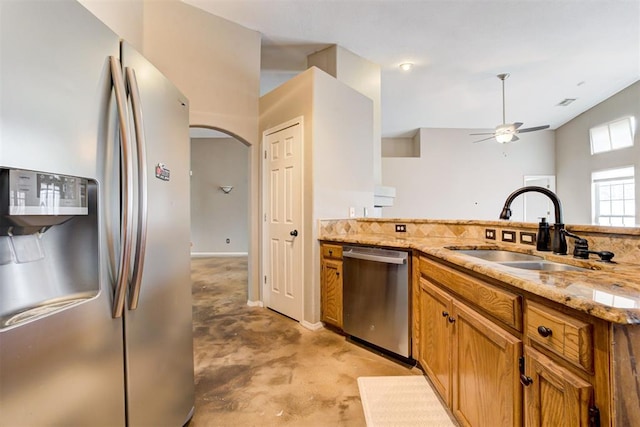 kitchen featuring ceiling fan, appliances with stainless steel finishes, sink, and light stone counters