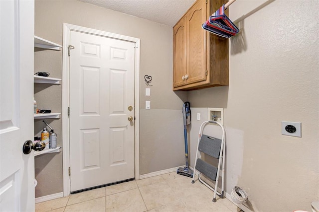 laundry area featuring light tile patterned flooring, cabinets, hookup for a washing machine, electric dryer hookup, and a textured ceiling