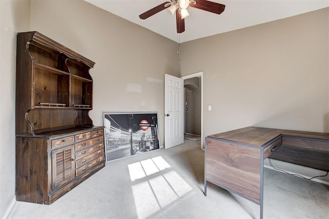 carpeted office space featuring ceiling fan