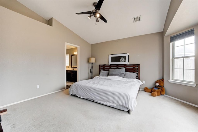 carpeted bedroom featuring vaulted ceiling, ceiling fan, and ensuite bath