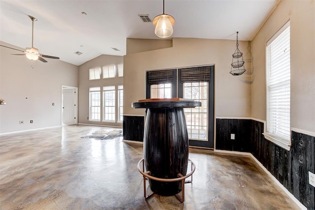 interior space with ceiling fan, concrete flooring, and high vaulted ceiling