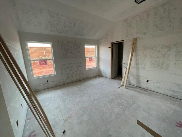 unfurnished bedroom with vaulted ceiling and multiple windows