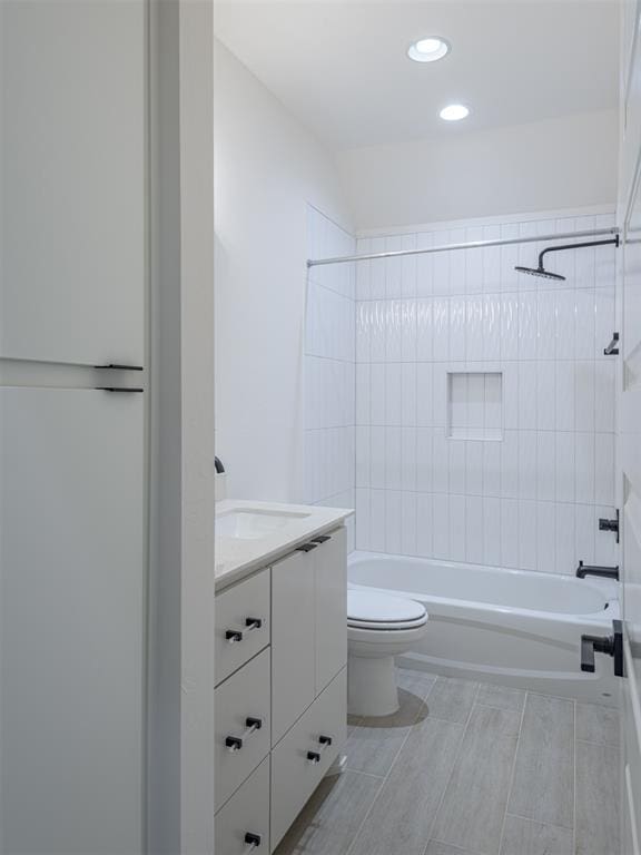 full bathroom featuring vanity, toilet, and tiled shower / bath combo