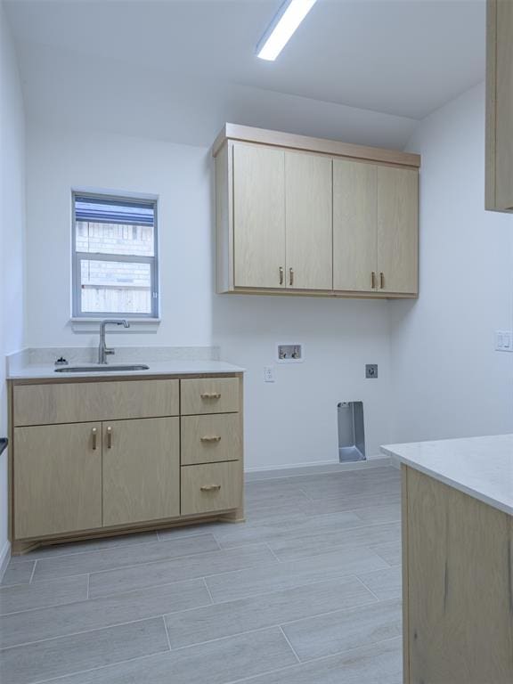 laundry area with sink, cabinets, electric dryer hookup, hookup for a washing machine, and light hardwood / wood-style floors