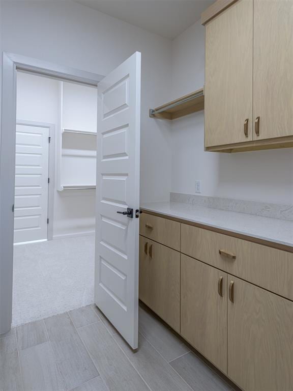 kitchen featuring light brown cabinets and light colored carpet