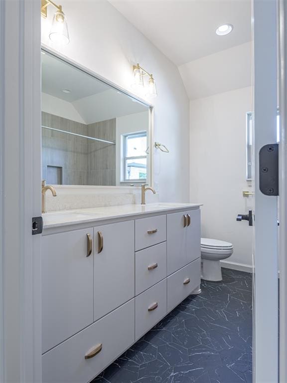 bathroom with vanity, toilet, tiled shower, and vaulted ceiling