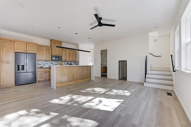 kitchen featuring a center island, ceiling fan, light wood-type flooring, tasteful backsplash, and stainless steel fridge with ice dispenser