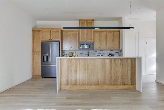 kitchen featuring tasteful backsplash, a kitchen island with sink, stainless steel appliances, and light wood-type flooring