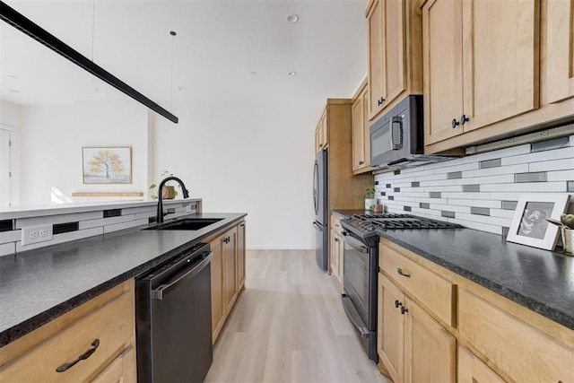 kitchen with sink, light brown cabinets, tasteful backsplash, light hardwood / wood-style floors, and appliances with stainless steel finishes