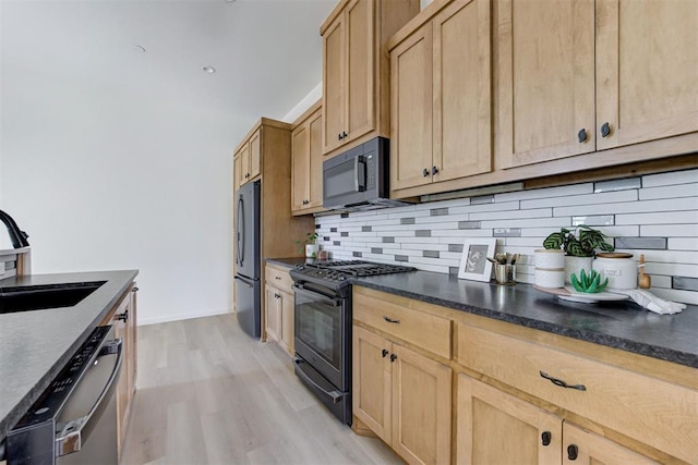 kitchen with light brown cabinetry, backsplash, sink, black appliances, and light hardwood / wood-style flooring