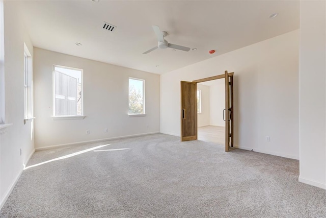 carpeted spare room featuring ceiling fan