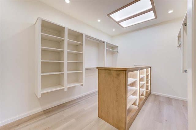 walk in closet with light hardwood / wood-style flooring