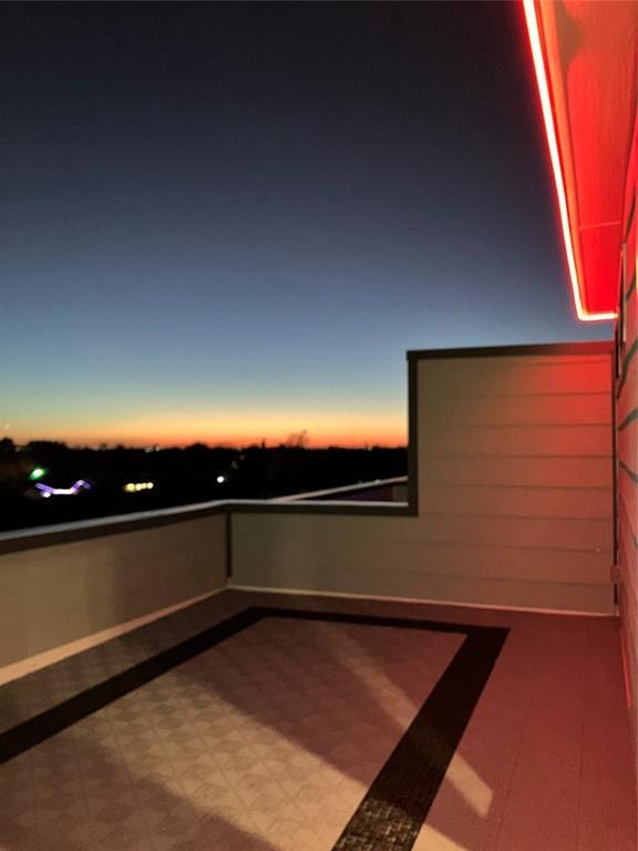 patio terrace at dusk featuring a balcony