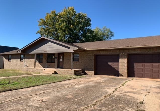 single story home with a front yard and a garage