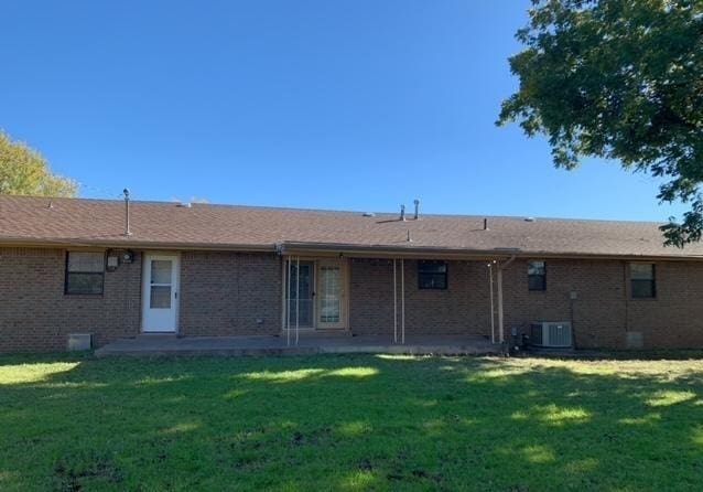 back of house with a lawn and central AC