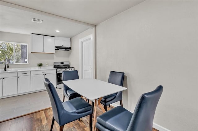 dining room with light hardwood / wood-style flooring and sink