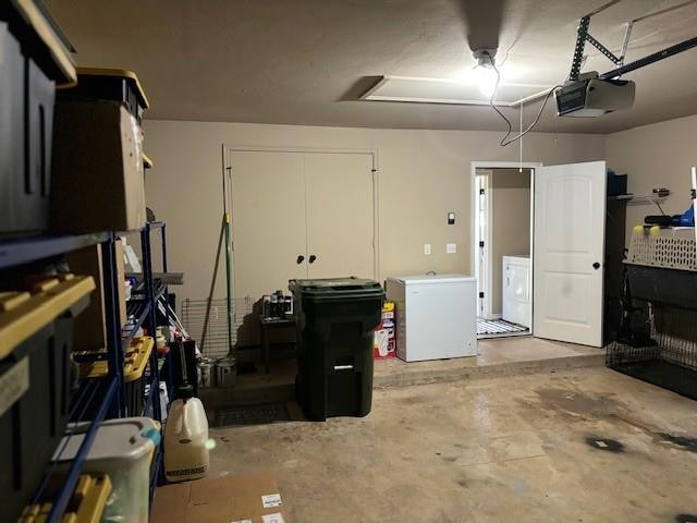 garage with white refrigerator, a garage door opener, and washer and clothes dryer