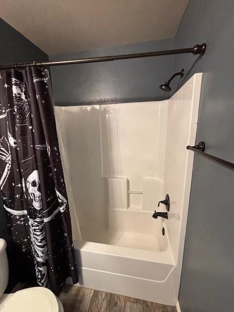 bathroom with hardwood / wood-style floors, toilet, and shower / tub combo