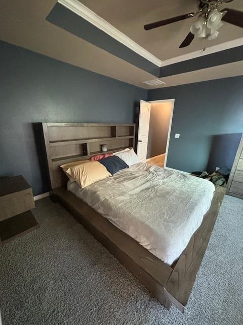 carpeted bedroom with a raised ceiling, ceiling fan, and ornamental molding