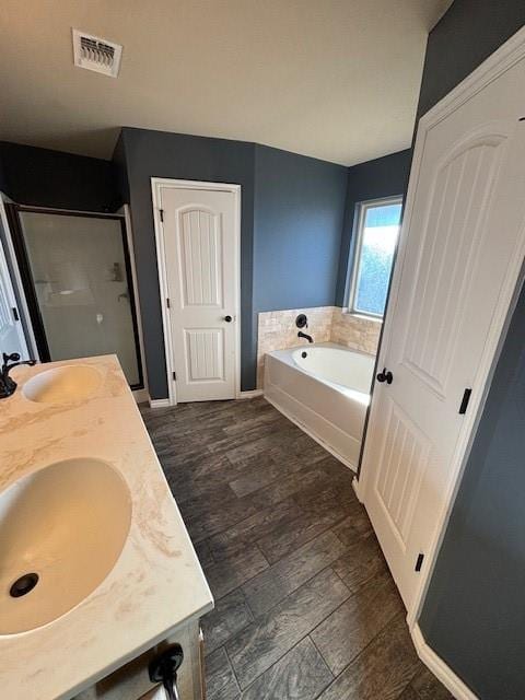 bathroom featuring vanity, wood-type flooring, and plus walk in shower