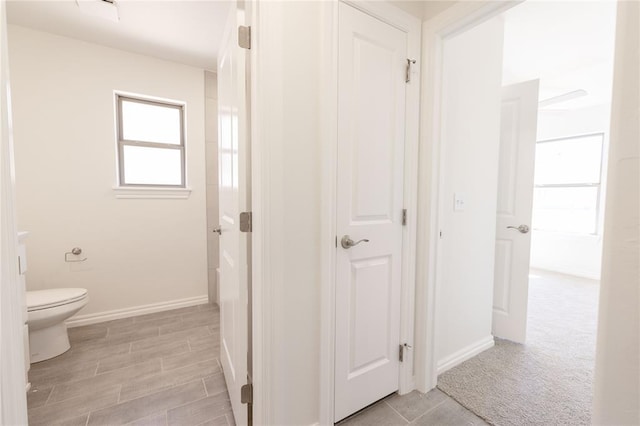 bathroom with toilet and baseboards