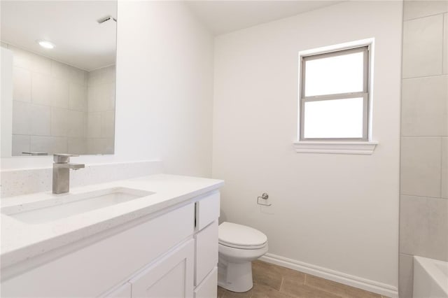 bathroom with vanity, baseboards, walk in shower, toilet, and a washtub