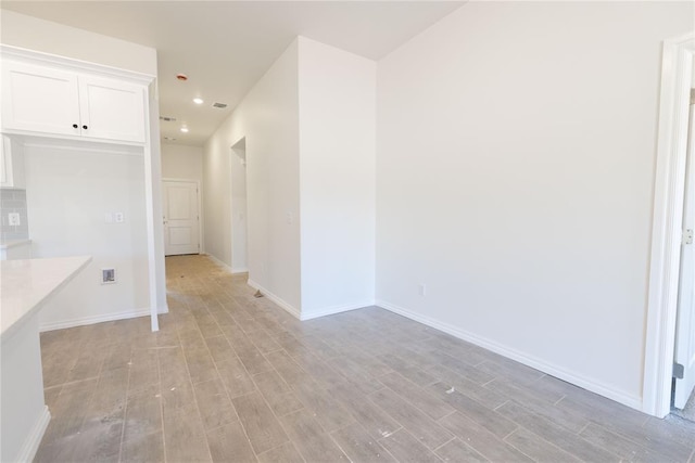 spare room with recessed lighting, baseboards, and light wood-style floors