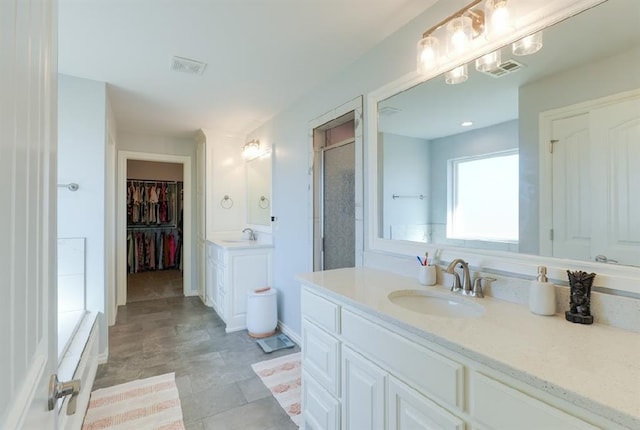 bathroom featuring vanity and a shower with door