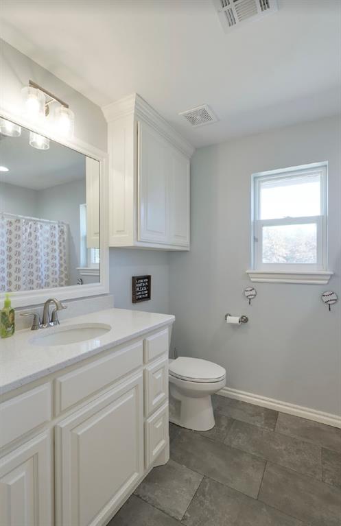 bathroom featuring walk in shower, vanity, and toilet