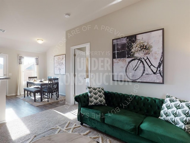 living room featuring vaulted ceiling and hardwood / wood-style flooring