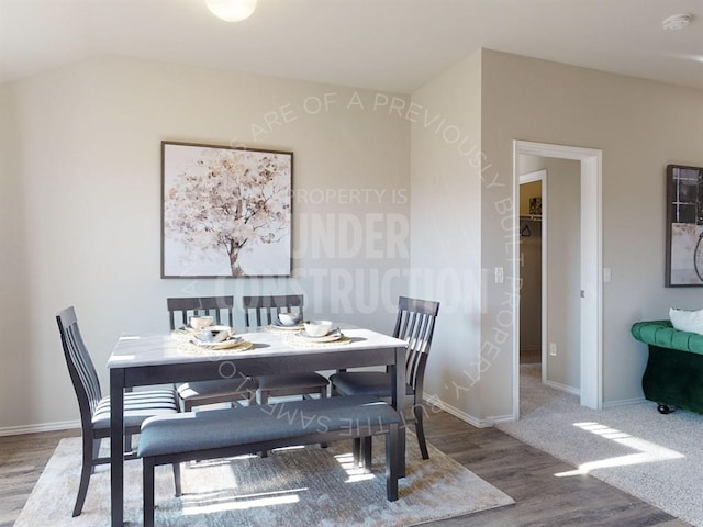 dining space featuring lofted ceiling and hardwood / wood-style flooring