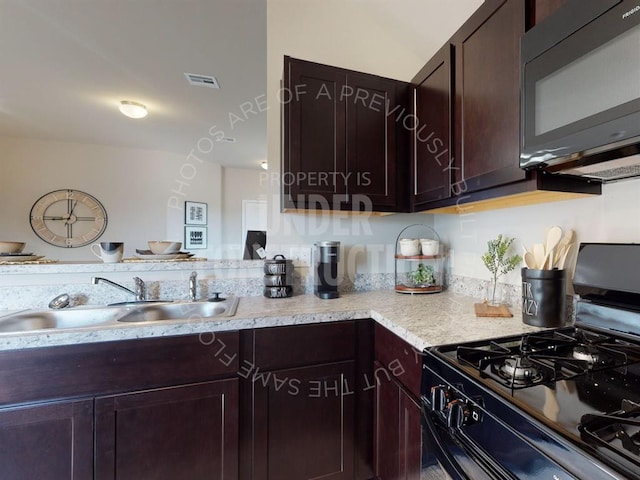 kitchen with decorative backsplash, black gas range oven, dark brown cabinetry, and sink