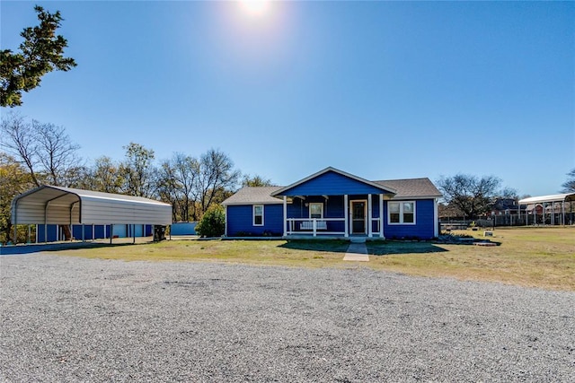 view of front facade featuring a front lawn, covered porch, and a carport