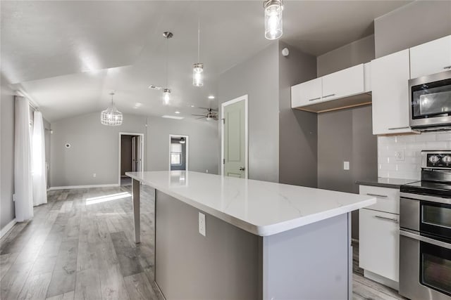 kitchen with pendant lighting, a center island, ceiling fan, appliances with stainless steel finishes, and white cabinetry