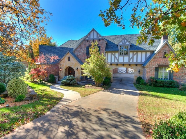 tudor-style house featuring a front yard