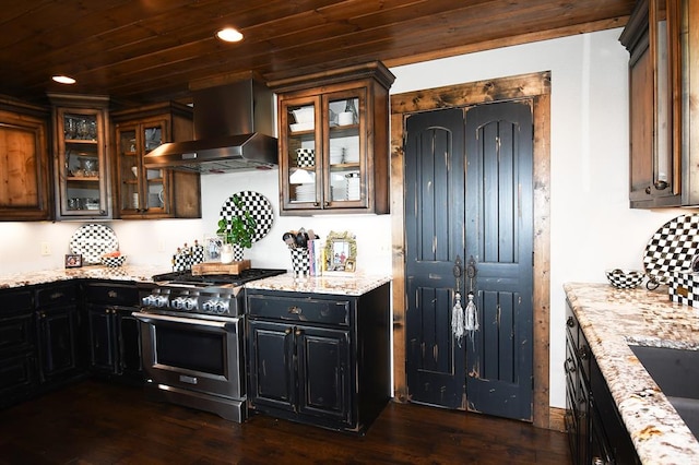 kitchen featuring dark hardwood / wood-style flooring, light stone counters, wood ceiling, wall chimney range hood, and stainless steel stove