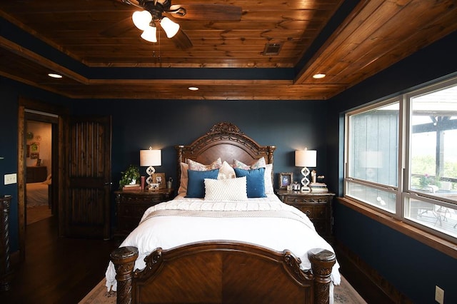 bedroom with dark hardwood / wood-style floors, a raised ceiling, ceiling fan, and wood ceiling