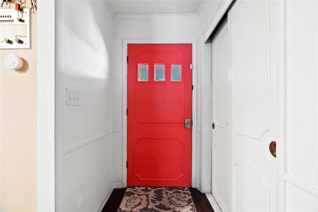 doorway featuring crown molding and dark wood-type flooring