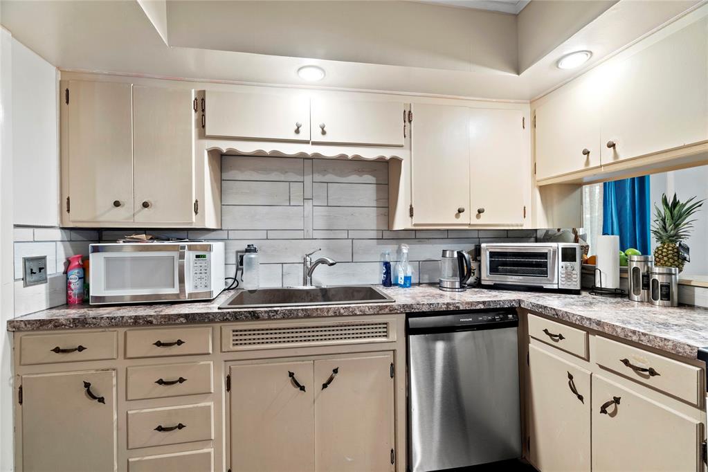 kitchen featuring dishwasher, cream cabinets, and sink