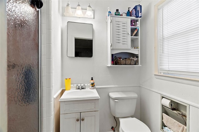 bathroom featuring vanity, toilet, walk in shower, and a wealth of natural light