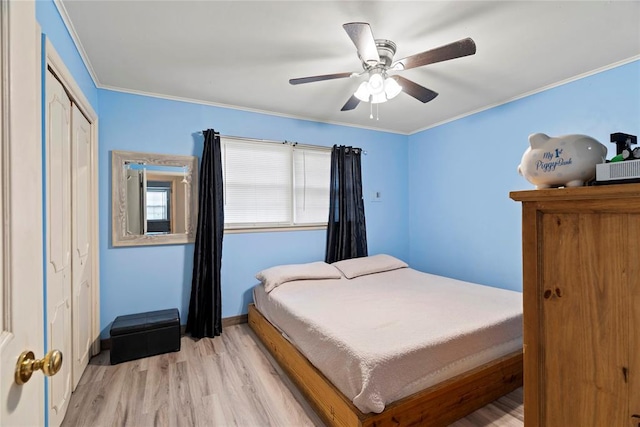 bedroom with ceiling fan, a closet, light hardwood / wood-style floors, and ornamental molding