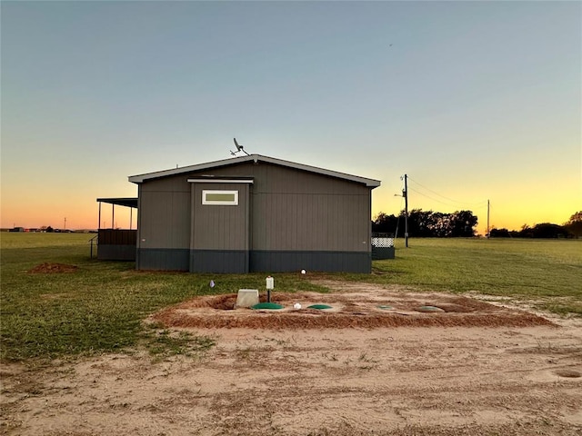 property exterior at dusk with a lawn