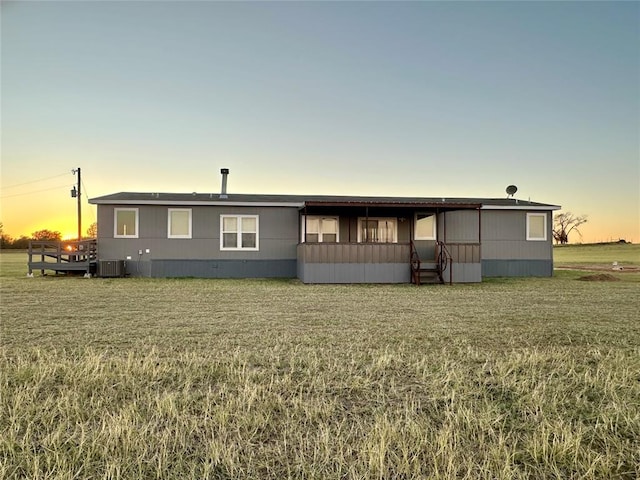 manufactured / mobile home with a lawn and central AC