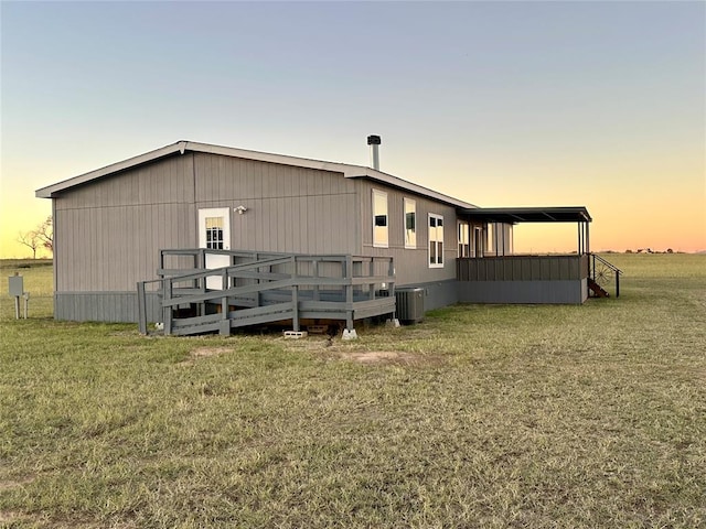 exterior space featuring central AC unit, a yard, and a wooden deck