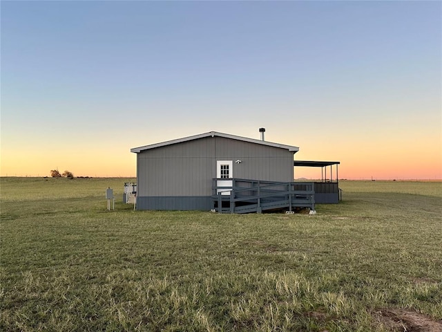 outdoor structure at dusk with a lawn and a rural view